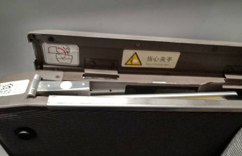 開蓋后可以看到一塊金屬板，這個(gè)就是藏起來的高鐵小桌板，向上將其拉出。